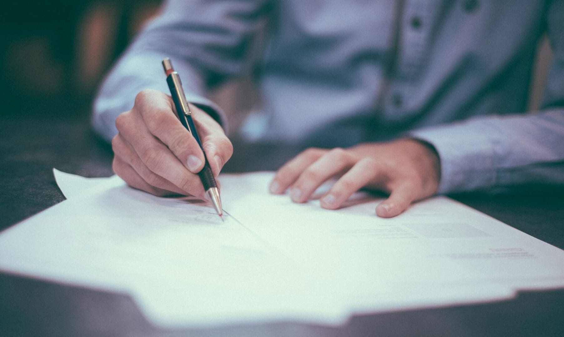 man writing on paper